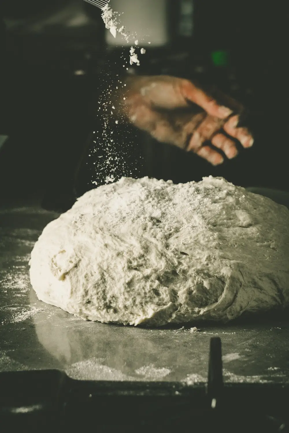 Two guys busy in the kitchen preparing pizza